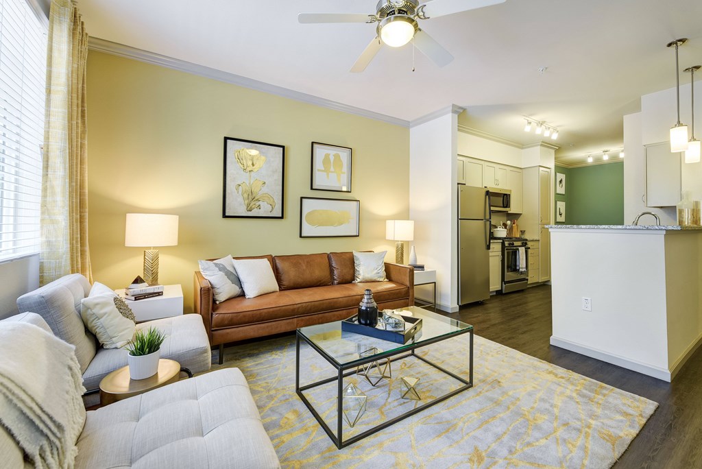 A living room with a grey couch, a coffee table, and a ceiling fan.