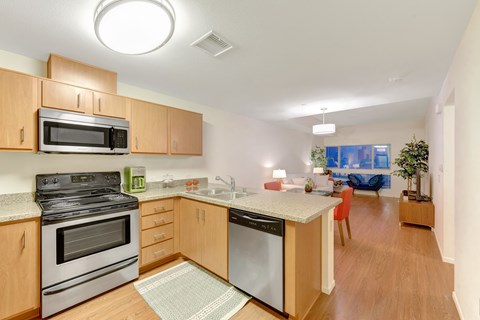 A kitchen with wooden cabinets and a stainless steel oven.