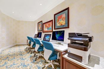 a conference room with computers and chairs and a printer