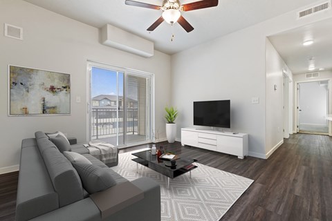 a living room with a ceiling fan and a large window