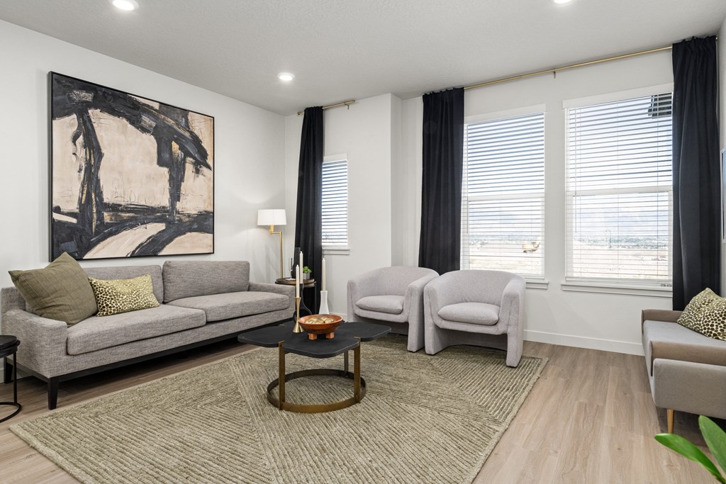 a living room with couches and chairs and a rug