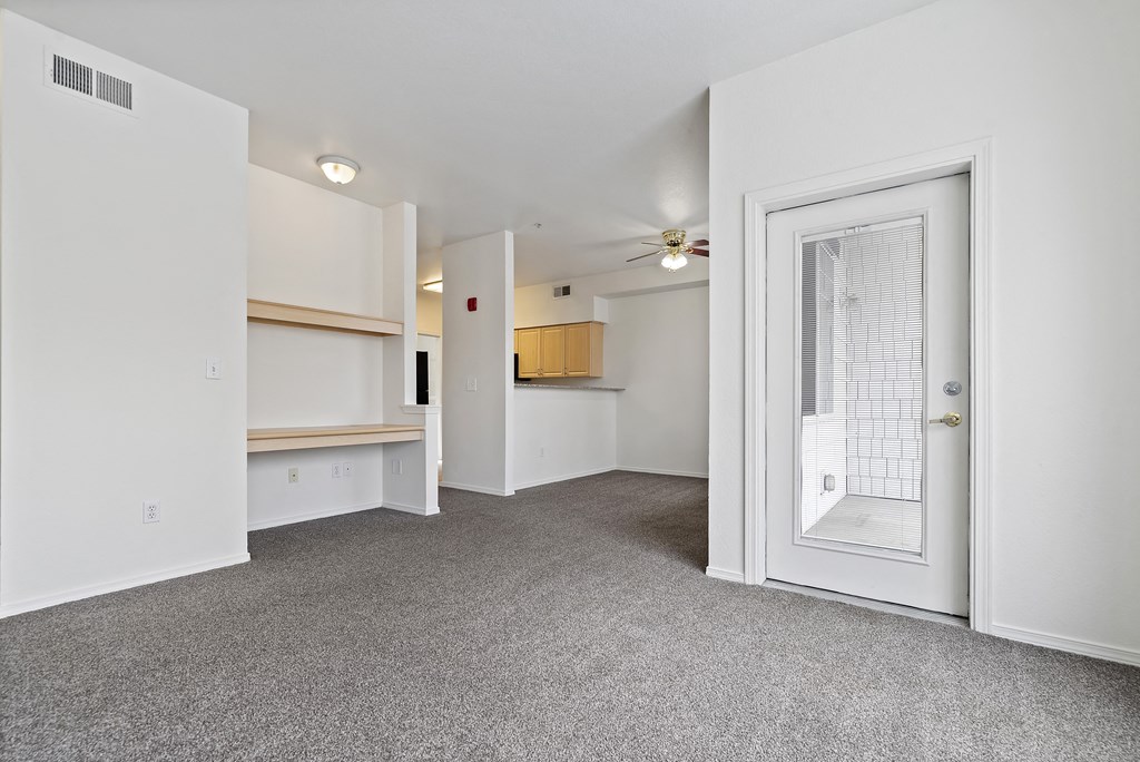 A room with a white door, a window, and a ceiling fan.