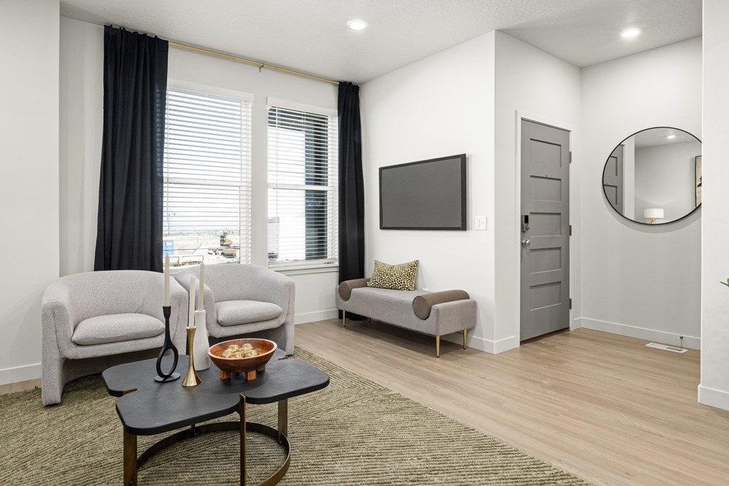 a living room with two chairs and a table and a television