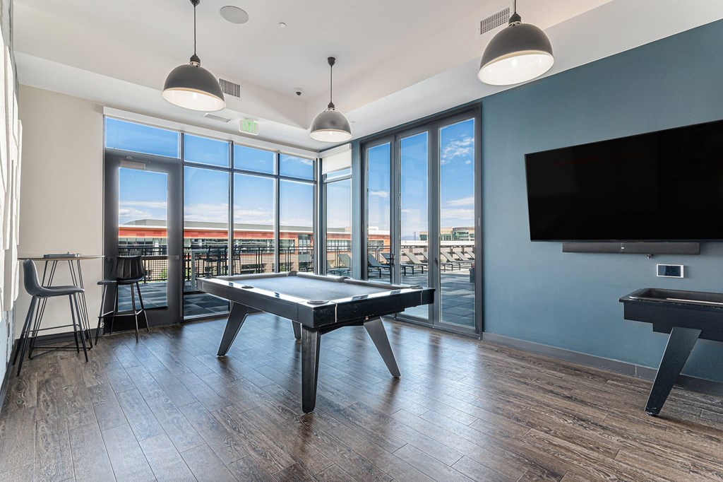 A room with a pool table and a television.