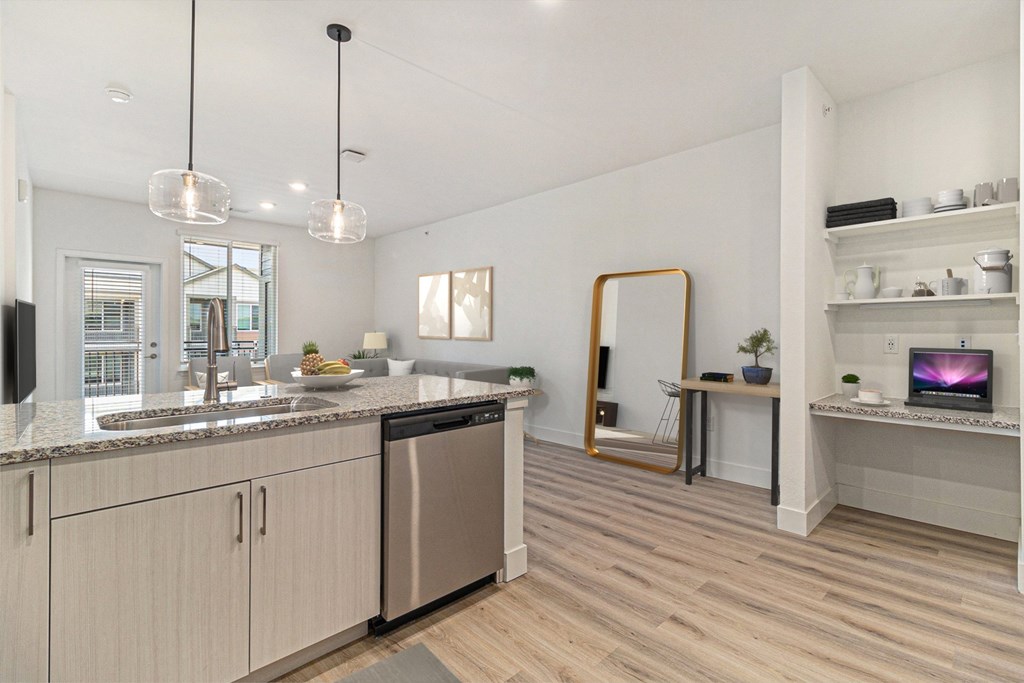 A modern kitchen with wooden floors and stainless steel appliances.