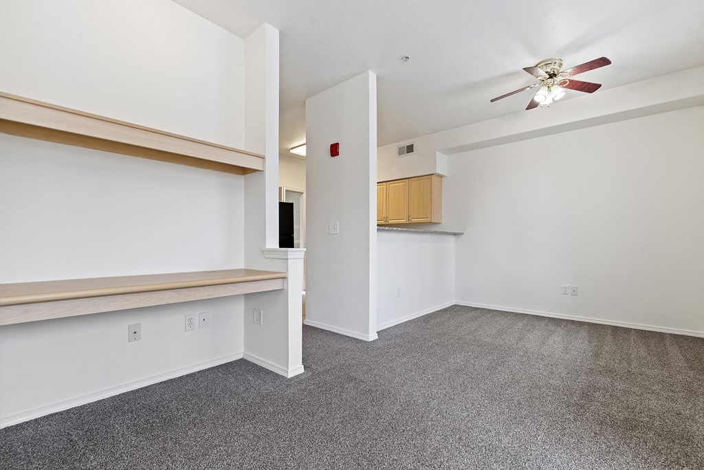 A room with a ceiling fan and a door leading to another room.