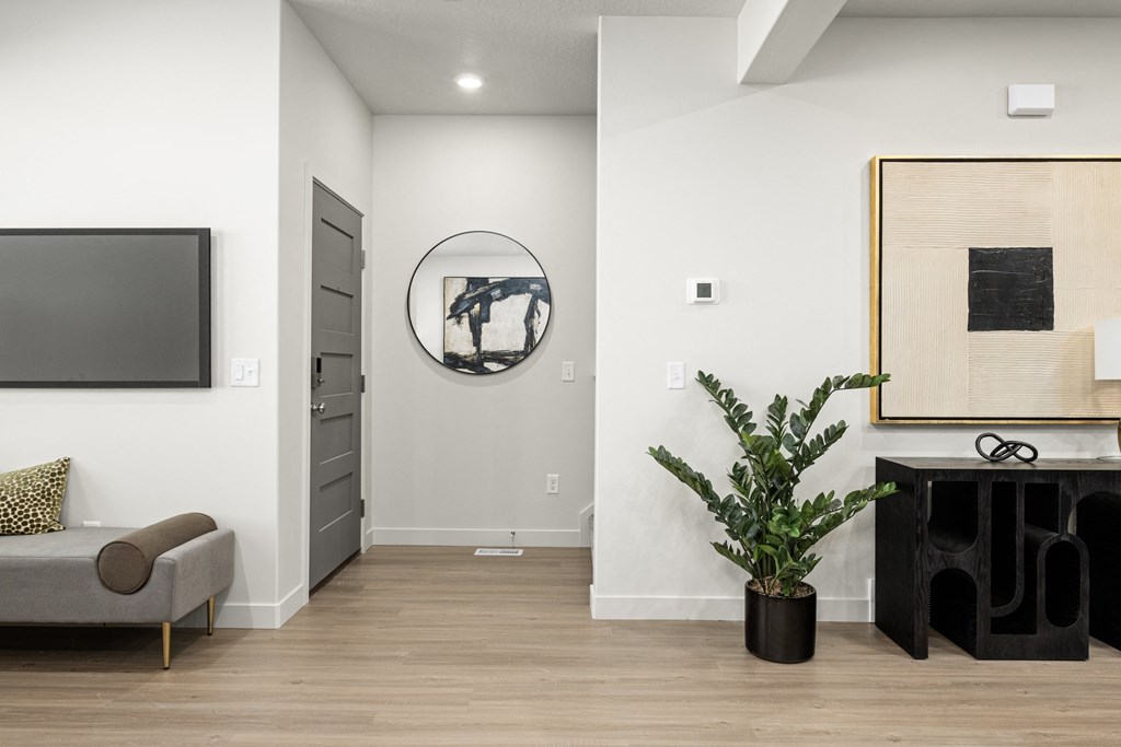 a living room with white walls and a mirror and a couch