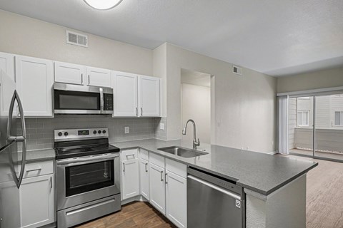 A kitchen with white cabinets and stainless steel appliances.