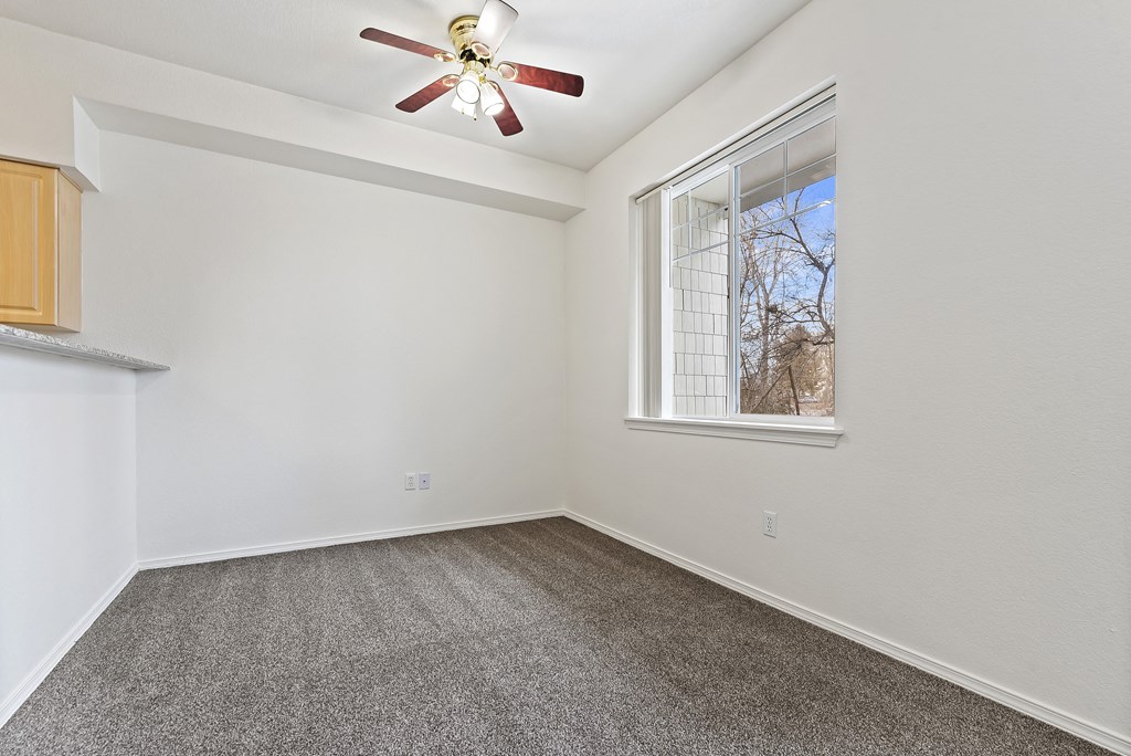A room with a ceiling fan and a window.