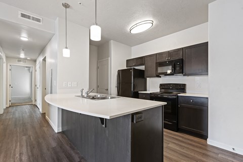 an empty kitchen with an island and black appliances