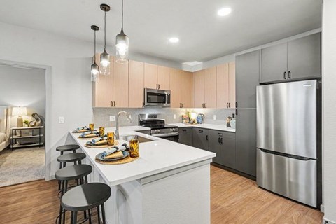 A modern kitchen with a white island and stainless steel appliances.