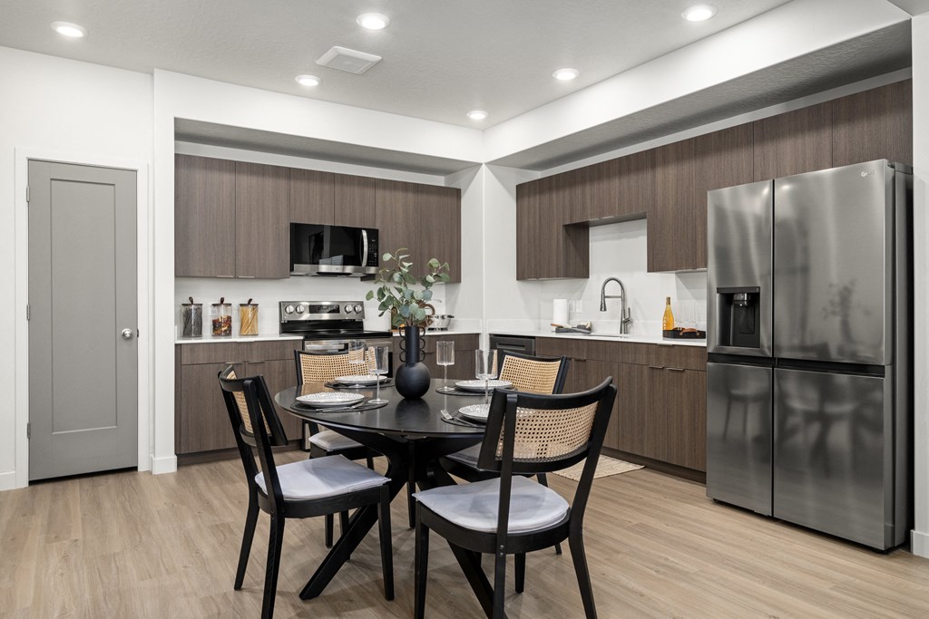 a kitchen and dining room with stainless steel appliances and a table and chairs