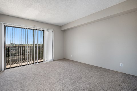 an empty living room with blinds on a window