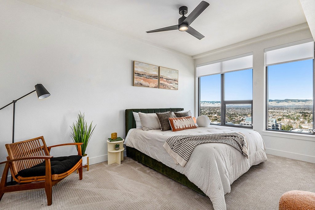 a bedroom with a bed and a ceiling fan and a view