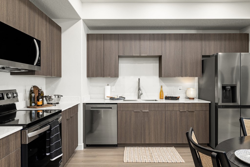 a modern kitchen with stainless steel appliances and wooden cabinets