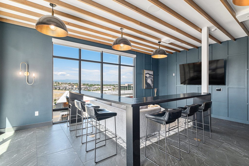A modern kitchen with a bar area and a view of the city.