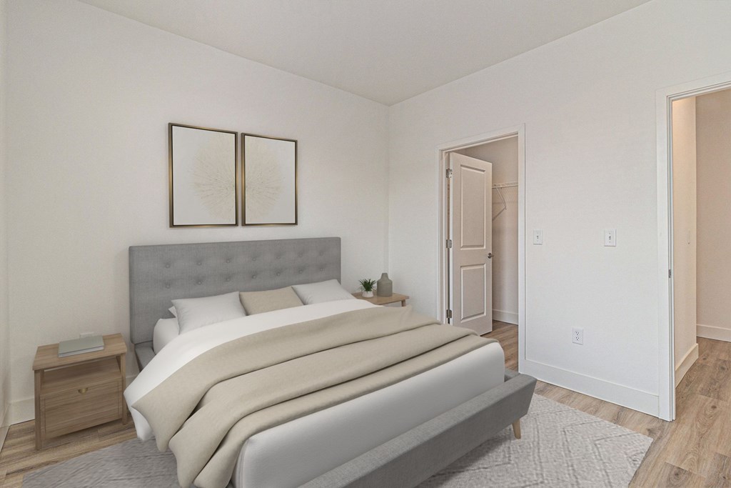 A bedroom with a large bed and a grey headboard.