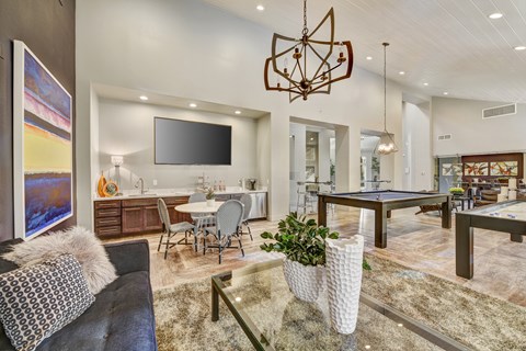 A modern living room with a pool table and a television.
