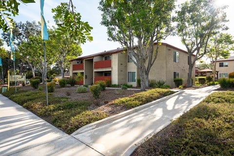 A sunny day at a residential area with apartment buildings and a sidewalk.