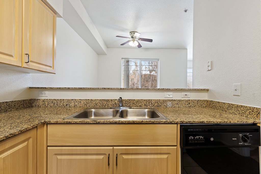 A kitchen with wooden cabinets and granite countertops.
