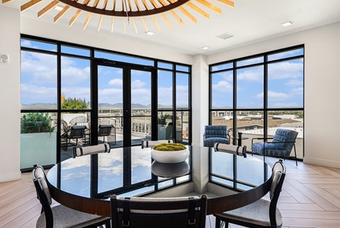 A modern dining room with a glass table and chairs.