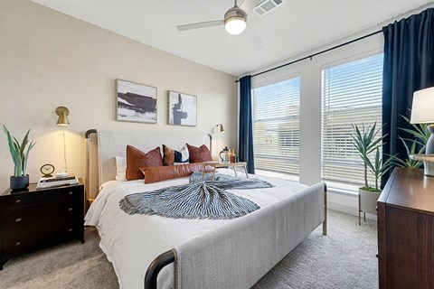 A bedroom with a large bed and a ceiling fan.