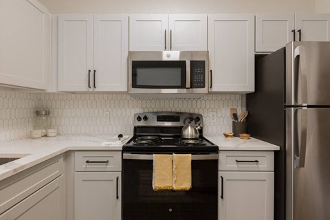 A kitchen with a black stove top oven and a black refrigerator.