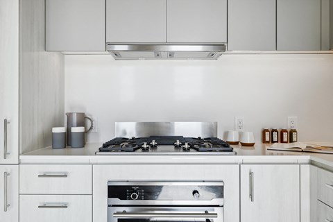 a kitchen with white cabinets and a stainless steel stove