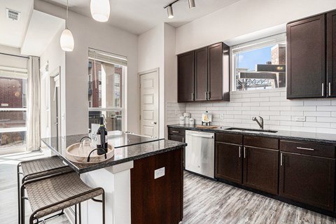 A kitchen with a black counter top and brown cabinets.