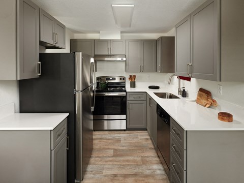 A modern kitchen with a black refrigerator and stainless steel appliances.