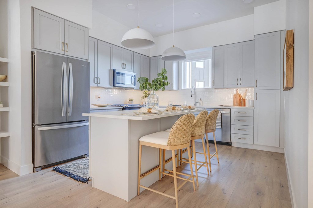 a kitchen with a Large Kitchen Island and three chairs