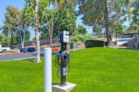 an electric vehicle charging station on the grass in a parking lot