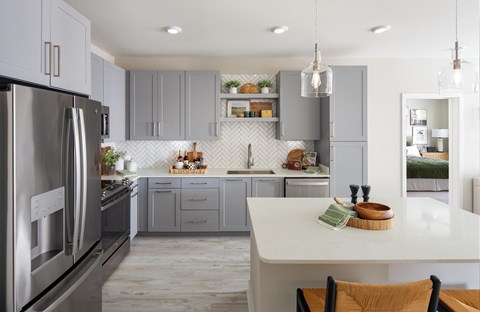 A modern kitchen with a large island and stainless steel appliances.