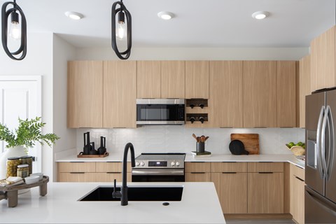 A modern kitchen with wooden cabinets and stainless steel appliances.