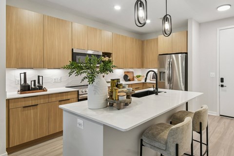 A modern kitchen with wooden cabinets and a white island.