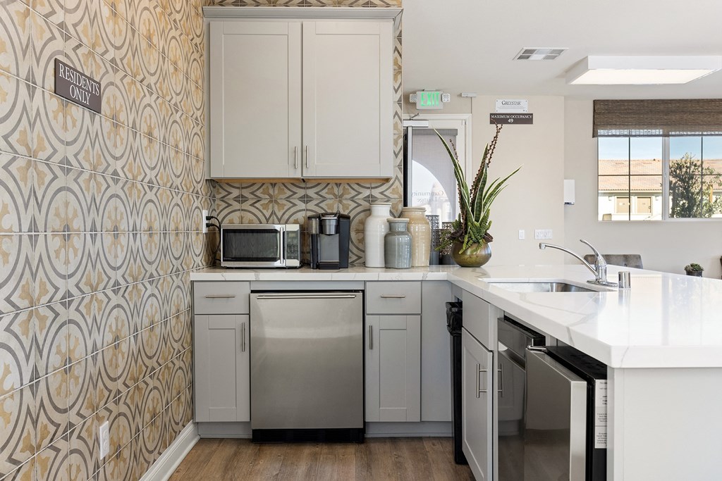 a kitchen with white cabinets and a stainless steel dishwasher
