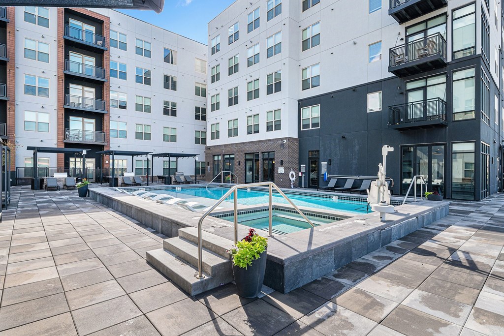 A pool surrounded by buildings and a potted plant.