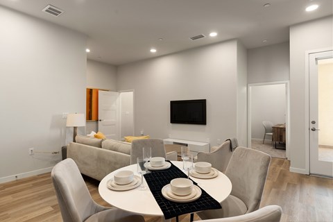 A modern dining room with a white table and chairs.