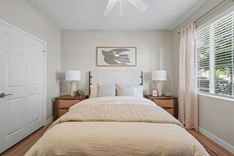 A bedroom with a large bed and two lamps on either side.