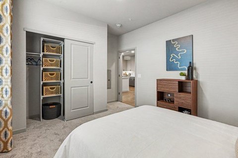 A bedroom with a large bed and a TV stand.