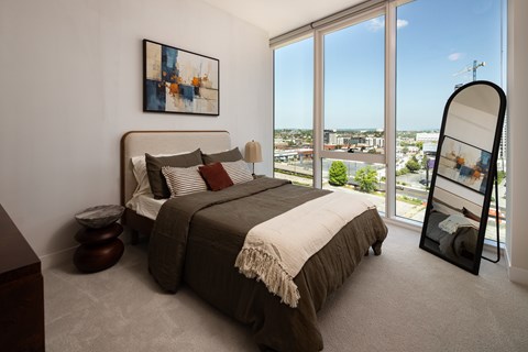 A bedroom with a large bed and a view of the city.