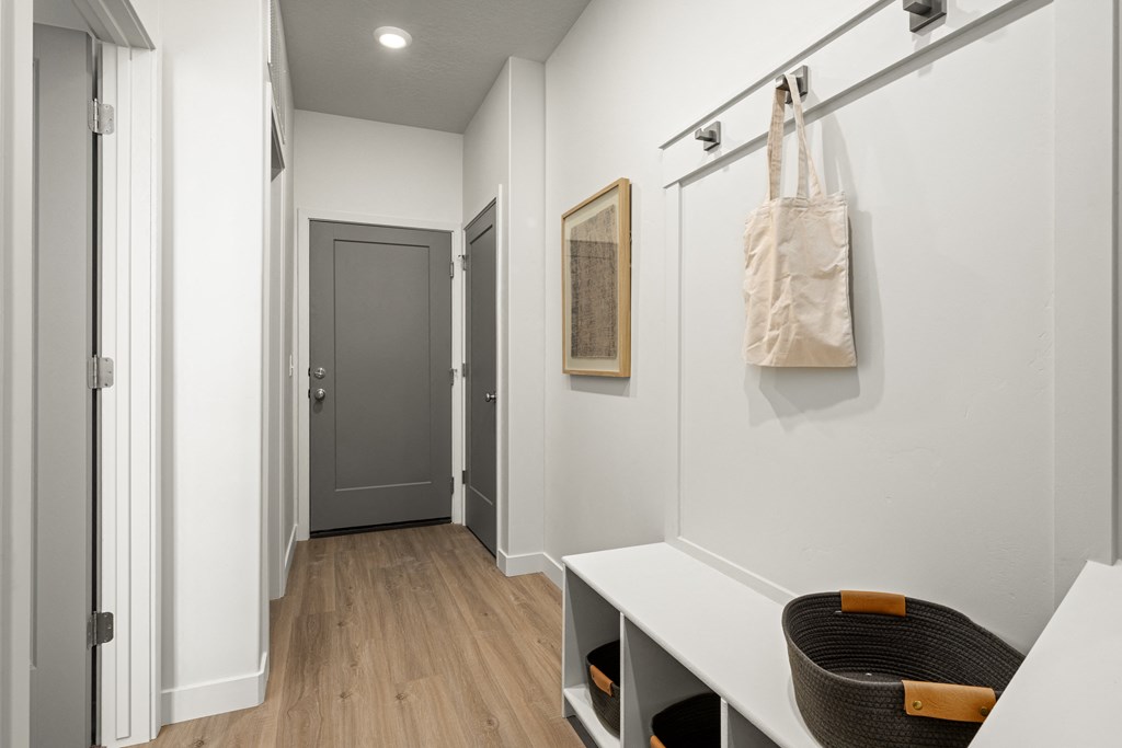 a hallway with white walls and a door and a hanging bag on the wall