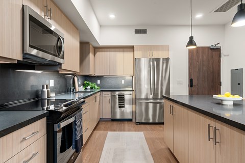 A modern kitchen with wooden cabinets and stainless steel appliances.