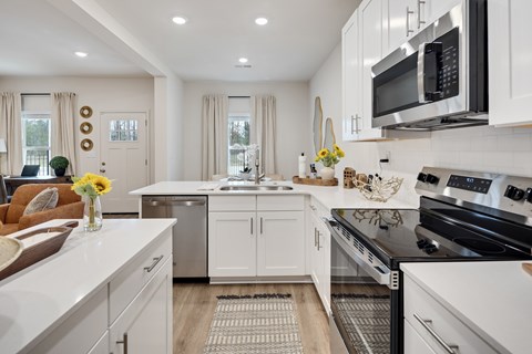 A modern kitchen with white cabinets and stainless steel appliances.