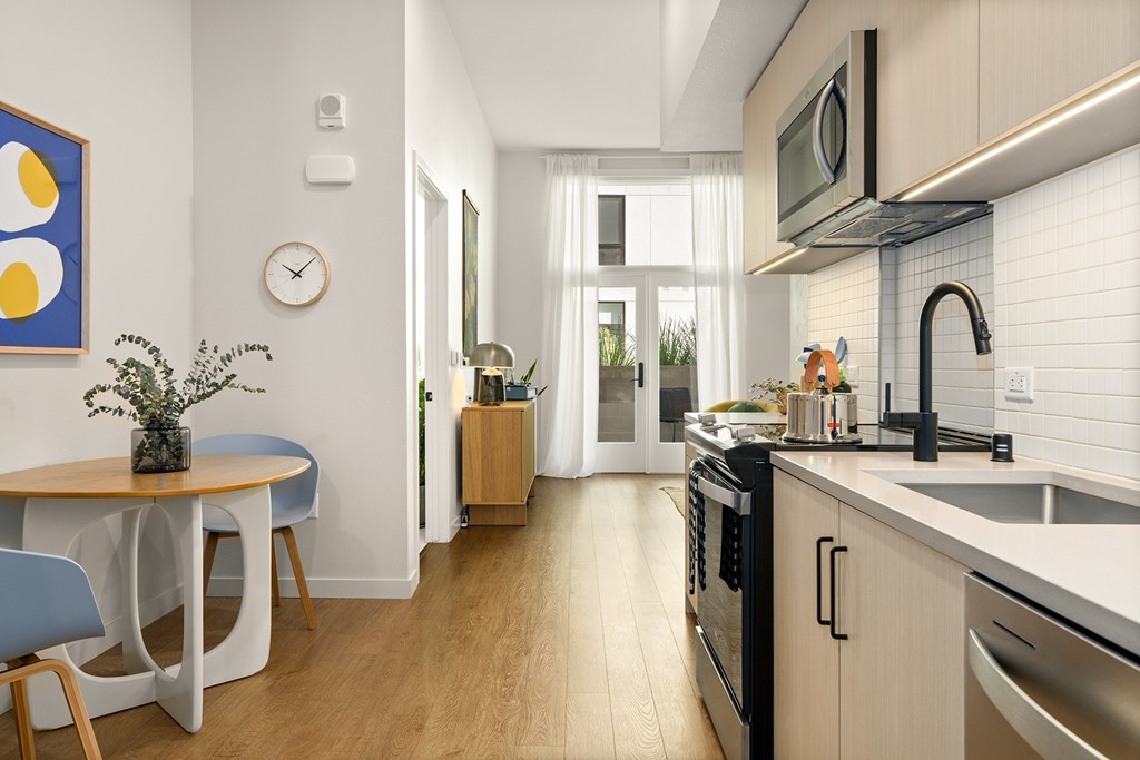 A kitchen with a table and chairs and a clock on the wall.