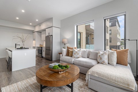 A modern living room with a white couch and a wooden coffee table.