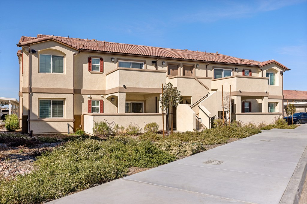 an apartment building with a sidewalk in front of it