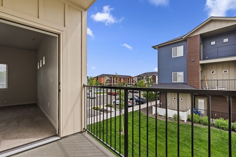 the view from the balcony of an apartment building with a yard and balcony railings