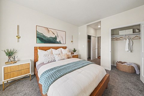 A bedroom with a large bed and a painting on the wall.