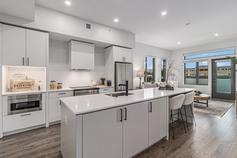 A modern kitchen with white cabinets and a central island.
